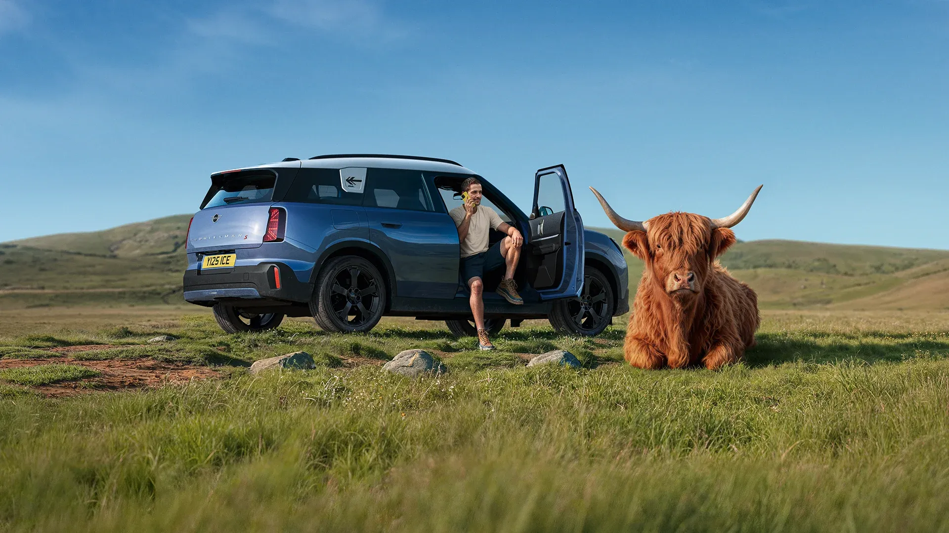MINI Proactive Care – man stands at the side of his MINI talking on the phone to Service Centre consultant.
