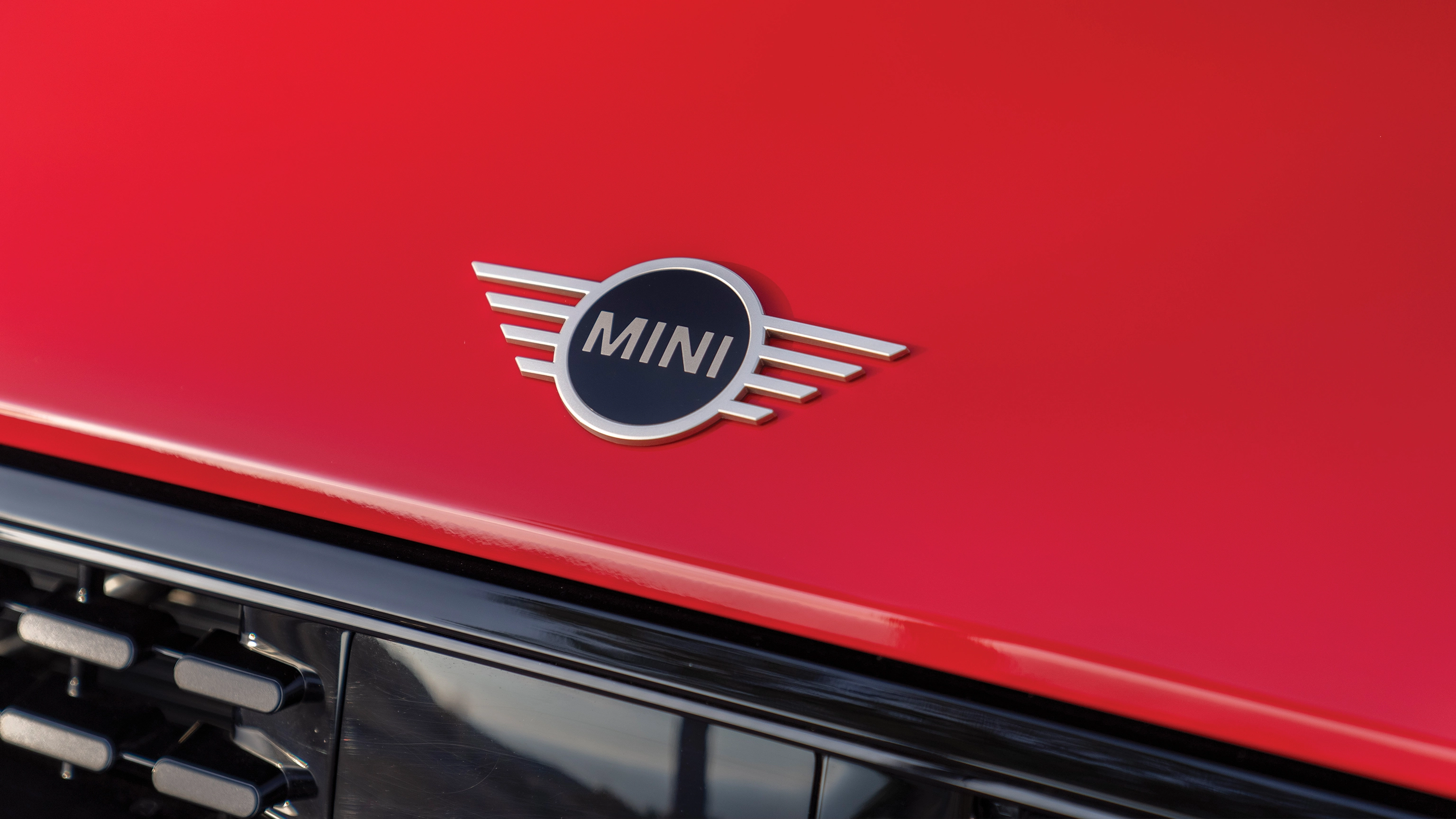 Rear left view of a parking MINI Cooper Convertible at the beach with two people