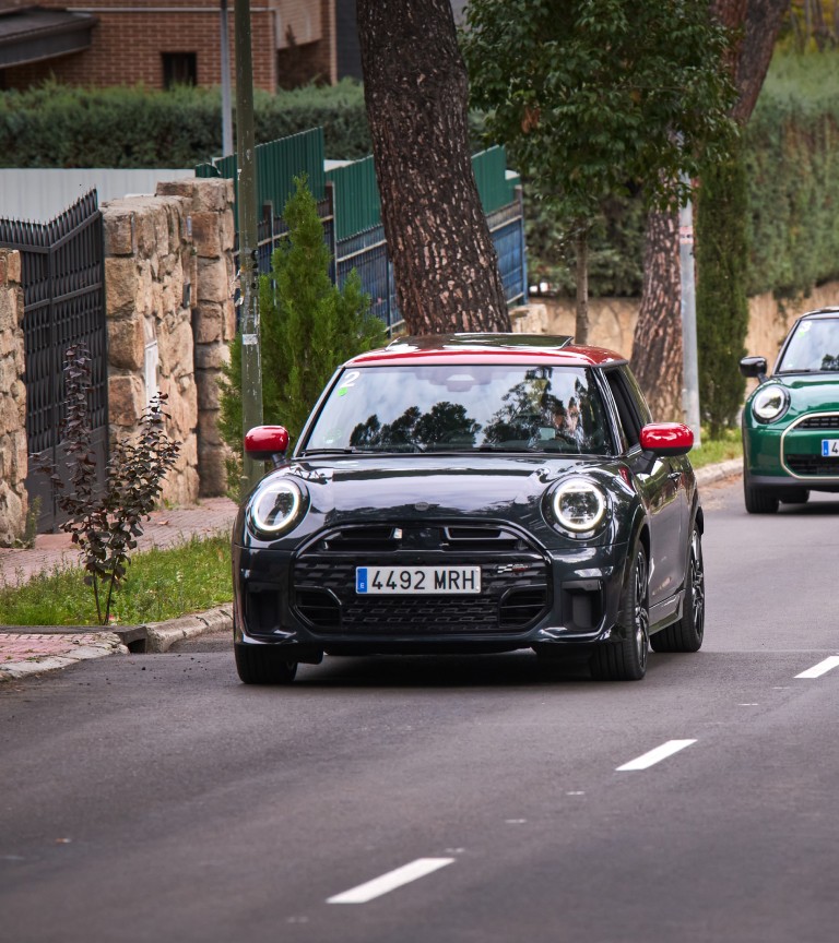 A group of MINI cars driving in a line on a scenic road